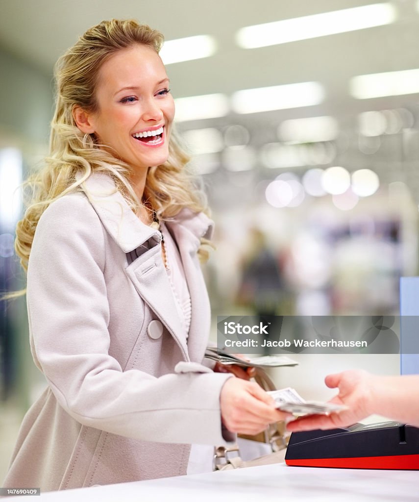 Feliz joven mujer dando dinero en efectivo Contador en el centro comercial - Foto de stock de 20 a 29 años libre de derechos