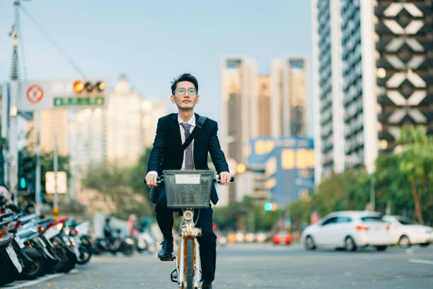 istock A business Asian man is riding a bicycle on his commute to or from work. 1476911442
