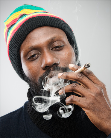 Man smoking a pipe on dark background