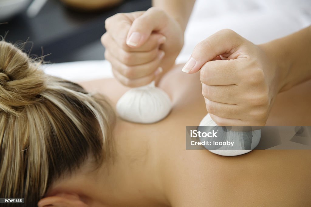 tthai herbal massage closeup of woman receiving massage with herbal balls Adult Stock Photo