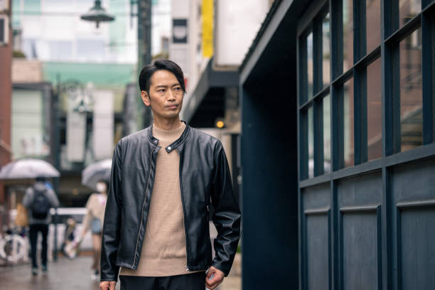 istock Japanese man in leather jacket walking in city 1476921833