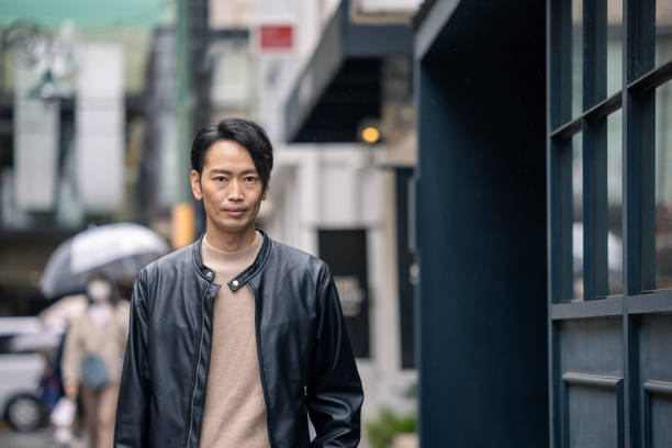 istock Japanese man in leather jacket walking in city 1476921889