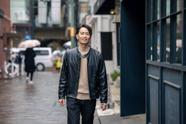 istock Japanese man in leather jacket walking in city 1476922006