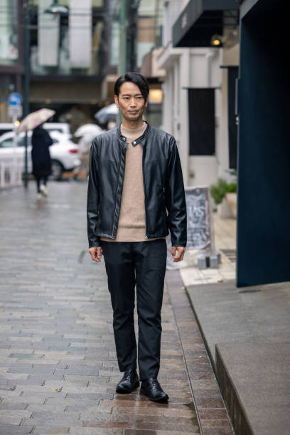 istock Japanese man in leather jacket walking in city 1476923358
