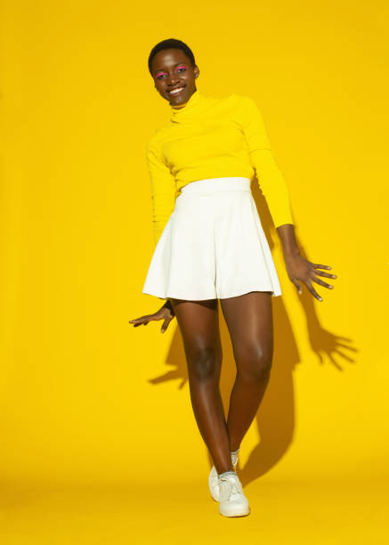 istock black beauty woman isolated on studio yellow background 1476924112