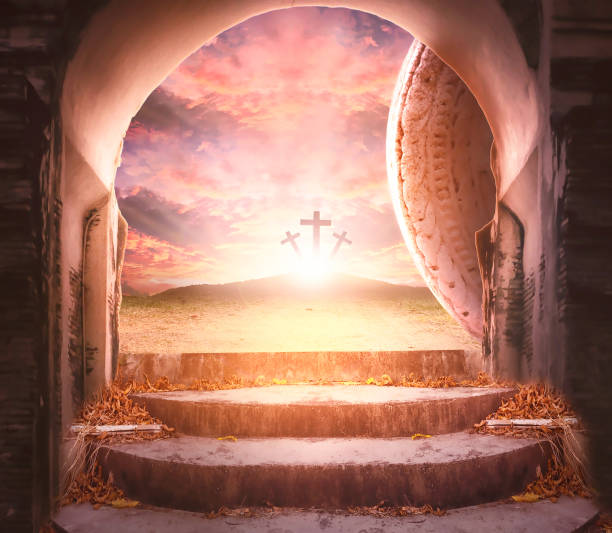 Easter and Good Friday concept, Empty tombstone with cross on mountain sunrise background stock photo
