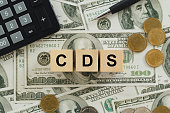 text CDS wrote on wooden cubes On top of the dollar bills. It is an abbreviation for credit default swap. a financial derivative that allows an investor to swap his credit risk.credit default swap