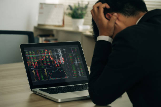 istock businessman holding his forehead while having headache analyzing stock exchange market crypto trading decreasing chart data fall down loss, desperate about losing money of crisis, recession, inflation 1476925659