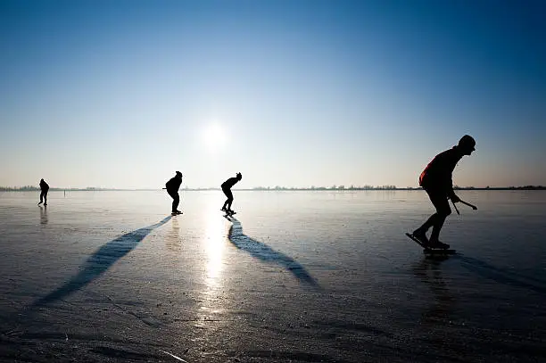 Photo of Four people ice skating together
