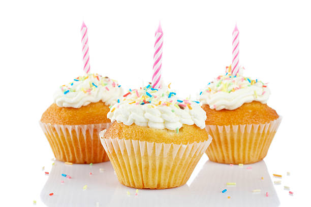 istock Three frosted cupcakes with sprinkles and candles 147694443
