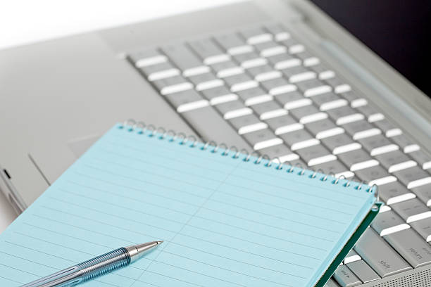 Laptop, note pad and pen stock photo