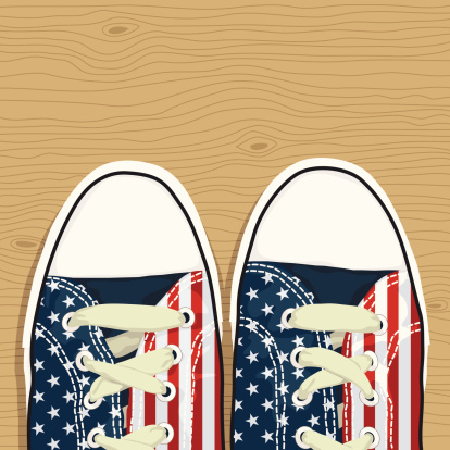 pair of shoes with american stars and stripes decoration, on wooden background, eps8 file no gradients or transparencies