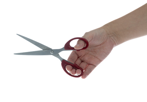 Woman holding a pair of scissors on white background