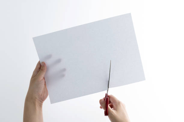 istock Scissors cutting a piece of blank paper 1476963264
