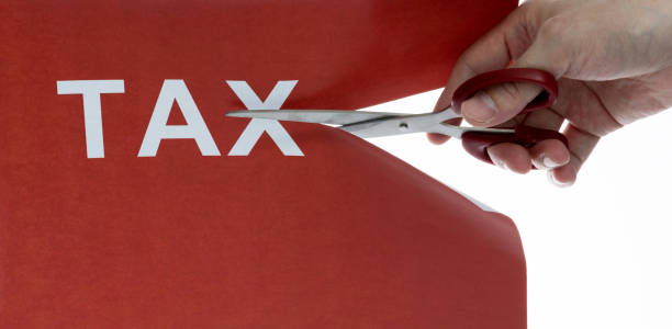 Cutting off the word tax with scissors stock photo