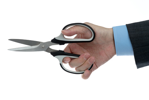 Businessman holding a pair of scissors on white background