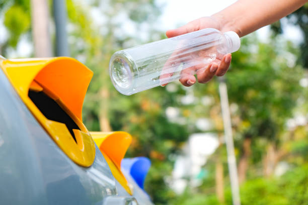 istock Please throw plastic bottles in the bin. Man littering the bins by separating waste for disposal such as recyclable plastic waste. environmental concept 1476966826