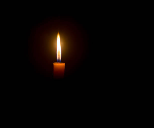 istock A single burning candle flame or light glowing on an orange cand 1476967127
