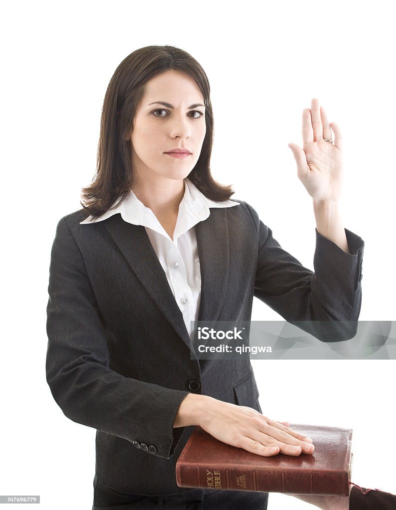 Caucasian Woman Swearing on a Bible Isolated White Background Serious Caucasian woman hand raised swearing on a bible.  Isolated on white.  - See lightbox for more One Woman Only Stock Photo