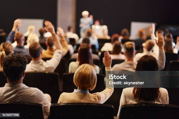 Back View Of Crowd Of People Raising Hands On A Seminar In Convention Center Stock Photo - Download Image Now