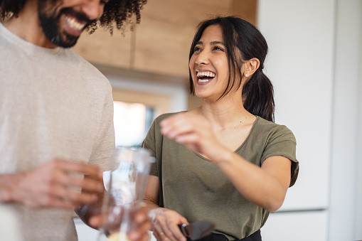 Cheerful Asian woman preparing Healthy Smoothie with Her Boyfriend