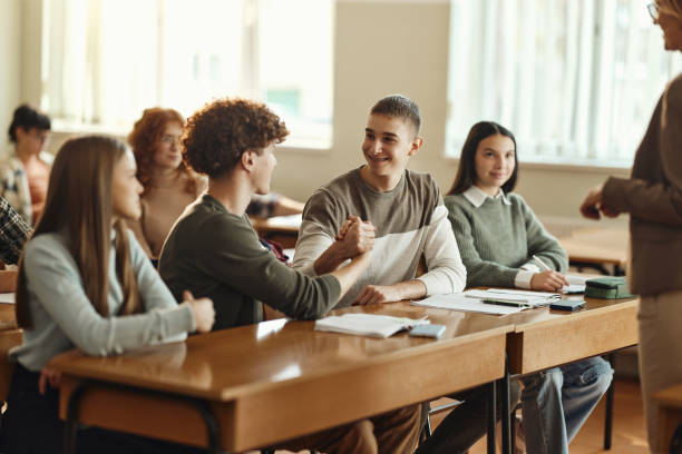 istock Happy male students greeting each other during a class at school. 1476978846