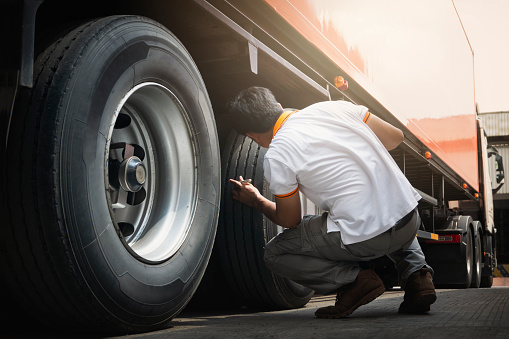 Truck Drivers Checking the Truck's Safety of Truck Wheels Tires. Auto Mechanic. Truck Inspection Safety Driving.