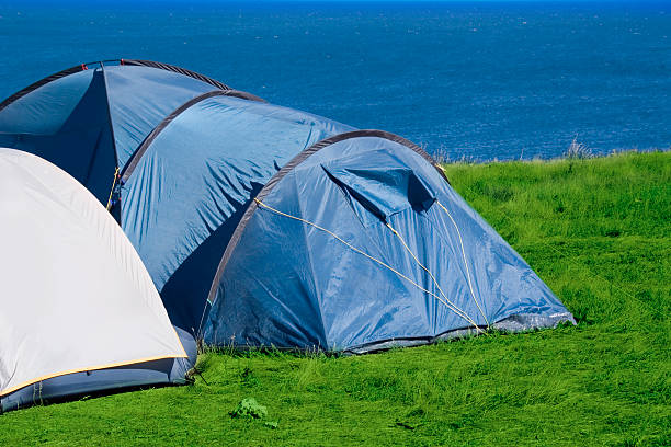 tents on grass at the sea shore stock photo