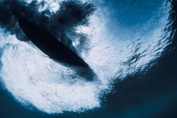 istock Wave underwater and surfer ride on surfboard in ocean. Underwater crashing wave and surfboard in transparent water 1476983471