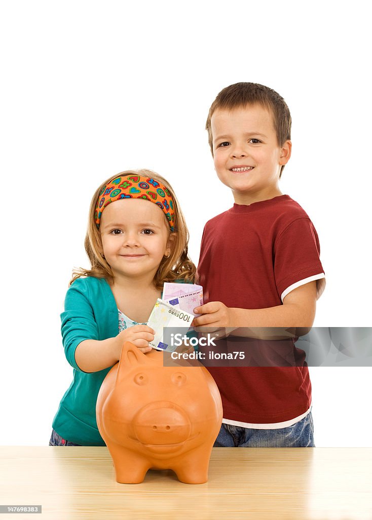 Finanacial education and discipline concept Finanacial education and discipline concept - kids feeding their piggy bank Beautiful People Stock Photo