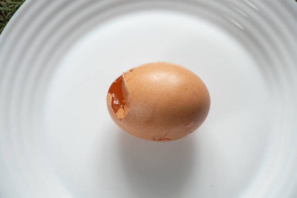 istock broken chicken egg lies on a white plate on the table close-up 1476985301