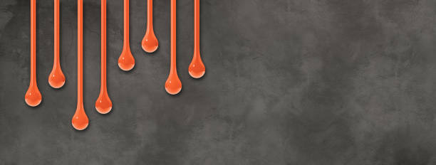 istock Orange ink drops on dark concrete wall. Horizontal banner 1476985426