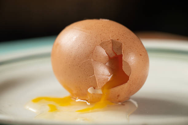 istock broken raw chicken egg brown lies on a plate close up 1476985695