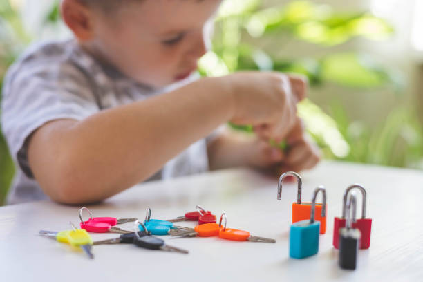 istock The child works with Montessori material with colored locks. Picks up keys. Develops fine motor skills. 1476990083
