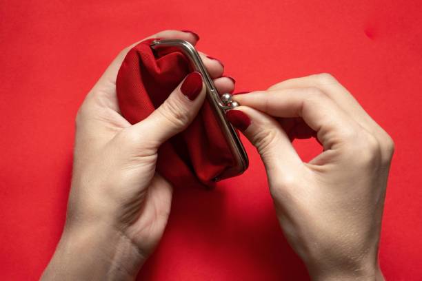 istock red old wallet and female hand on isolated background close-up 1476992194