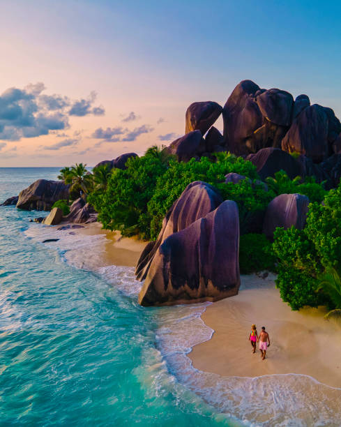 istock Anse Source d'Argent beach, La Digue Island, Seyshelles, Drone aerial view of La Digue Seychelles bird eye view, couple men and woman walking at the beach during sunset at a luxury vacation 1476993951