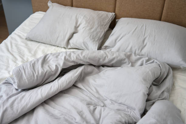 istock Crumpled bed with pillows, blanket and crumpled sheets in bedroom 1477000410