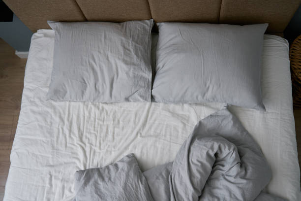 istock Crumpled bed with pillows, blanket and crumpled sheets in bedroom 1477000414