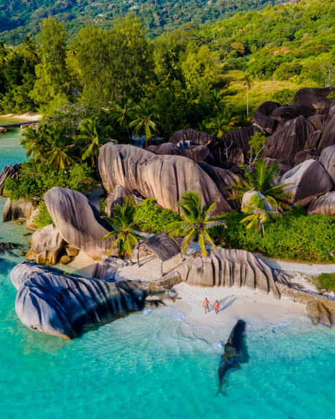 istock Anse Source d'Argent beach, La Digue Island, Seyshelles, Drone aerial view of La Digue Seychelles bird eye view, couple men and woman walking at the beach during sunset at a luxury vacation 1477000438