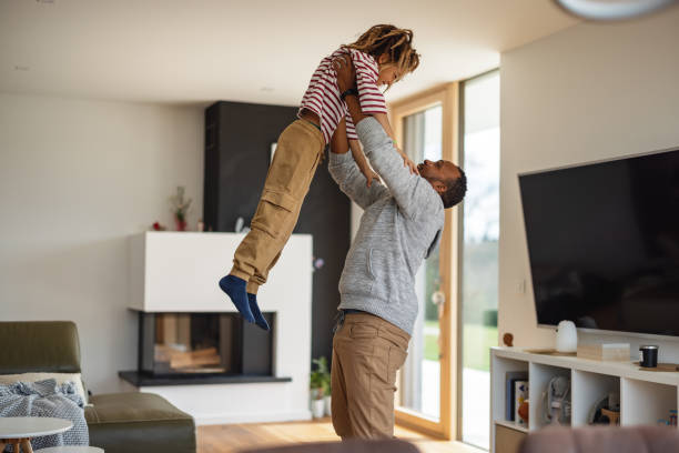 istock Father Throwing His Son In The Air At Home 1477001012