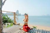 Woman doing yoga on the beach in Krabi