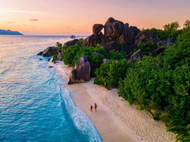 istock Anse Source d'Argent beach, La Digue Island, Seyshelles, Drone aerial view of La Digue Seychelles bird eye view, couple men and woman walking at the beach during sunset at a luxury vacation 1477004836