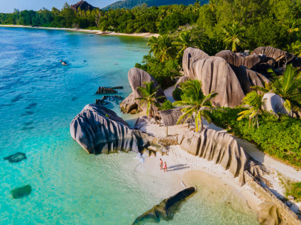 istock Anse Source d'Argent beach, La Digue Island, Seyshelles, Drone aerial view of La Digue Seychelles bird eye view, couple men and woman walking at the beach during sunset at a luxury vacation 1477008251