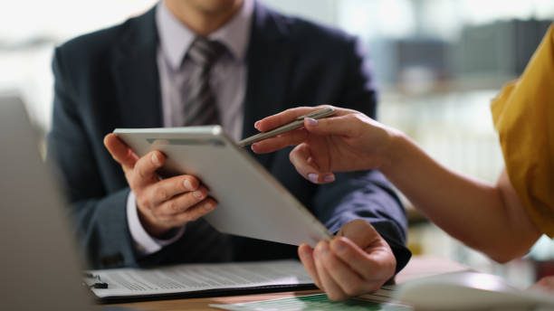 istock Business partners discussing information on tablet and showing screen with pen closeup 1477009492
