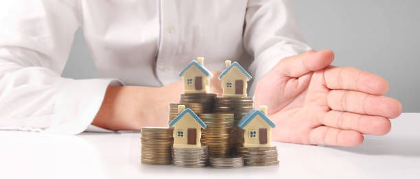 istock House Residential Structure in hand ,model house and coin 1477012570