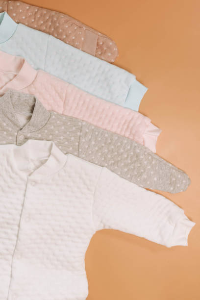 istock Multicolor Jumpsuits for newborns on a beige background 1477022340
