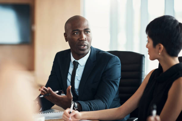 uomo nero, leadership e riunione aziendale in ufficio con la direzione esecutiva, il feedback degli investitori e la strategia. business manager professionista, discussione di gruppo e ceo in seminario sugli investimenti finanziari - amministratore delegato immagine foto e immagini stock