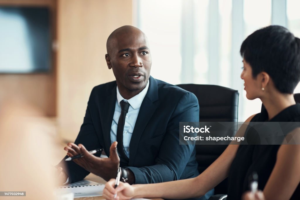 Black man, leadership and corporate meeting in office with executive management, investor feedback and strategy. Professional business manager, team discussion and CEO in financial investment seminar Lawyer Stock Photo