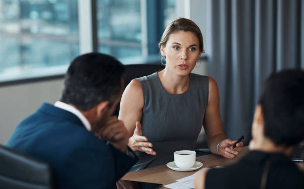 Serious woman talking to business clients in meeting negotiation, legal advice or professional advisory planning. Lawyer, manager or corporate people in conference room discussion for career strategy stock photo