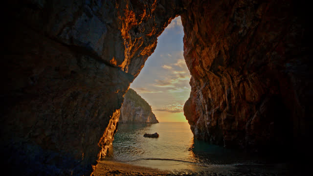 Natural arch over sea at San Nicola Arcella during sunset
